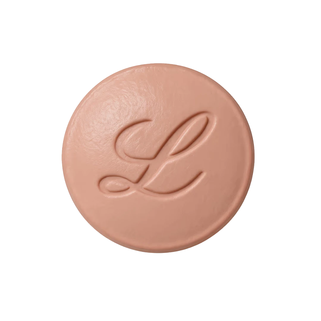 Round beige pressed powder compact with embossed leaf logo