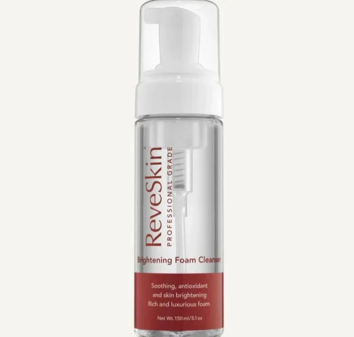 ReveSkin Brightening Foam Cleanser in a clear pump bottle. The label features the brand name and product description, highlighting its soothing, antioxidant, and skin-brightening properties. This luxurious foam cleanser is designed for professional use, with a net weight of 150 ml (5.1 oz). Ideal for enhancing skin radiance while providing a gentle cleansing experience.